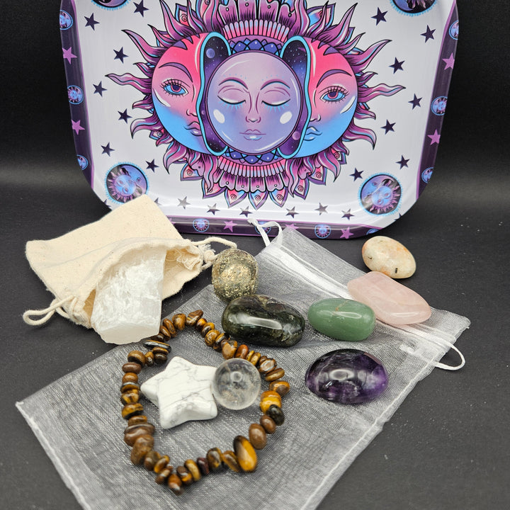 A crystal and gemstone set displayed on a dark surface, including a tiger&