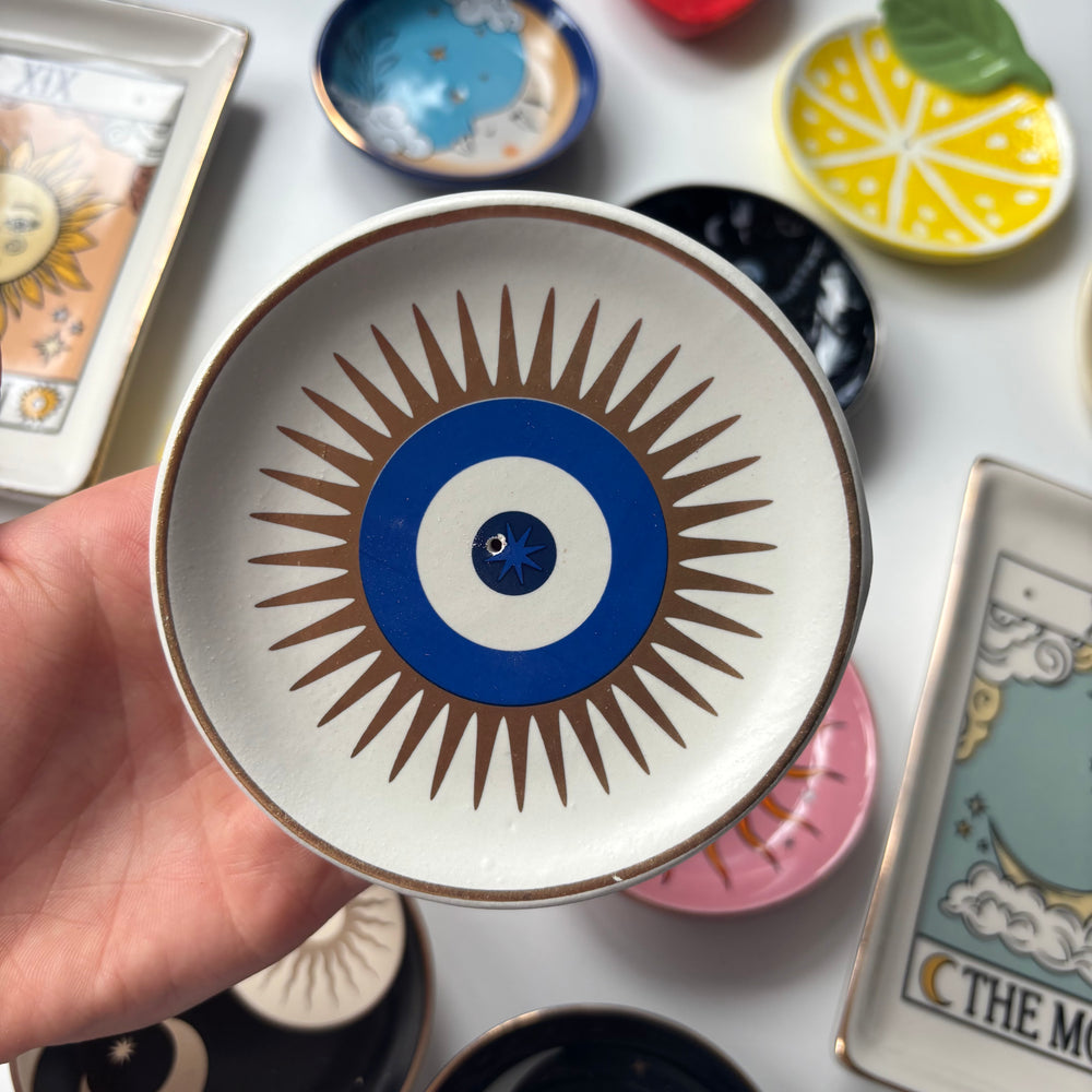 Decorative All Seeing Eye Incense Stick Holder held by a hand, surrounded by tarot cards and other decorative items.