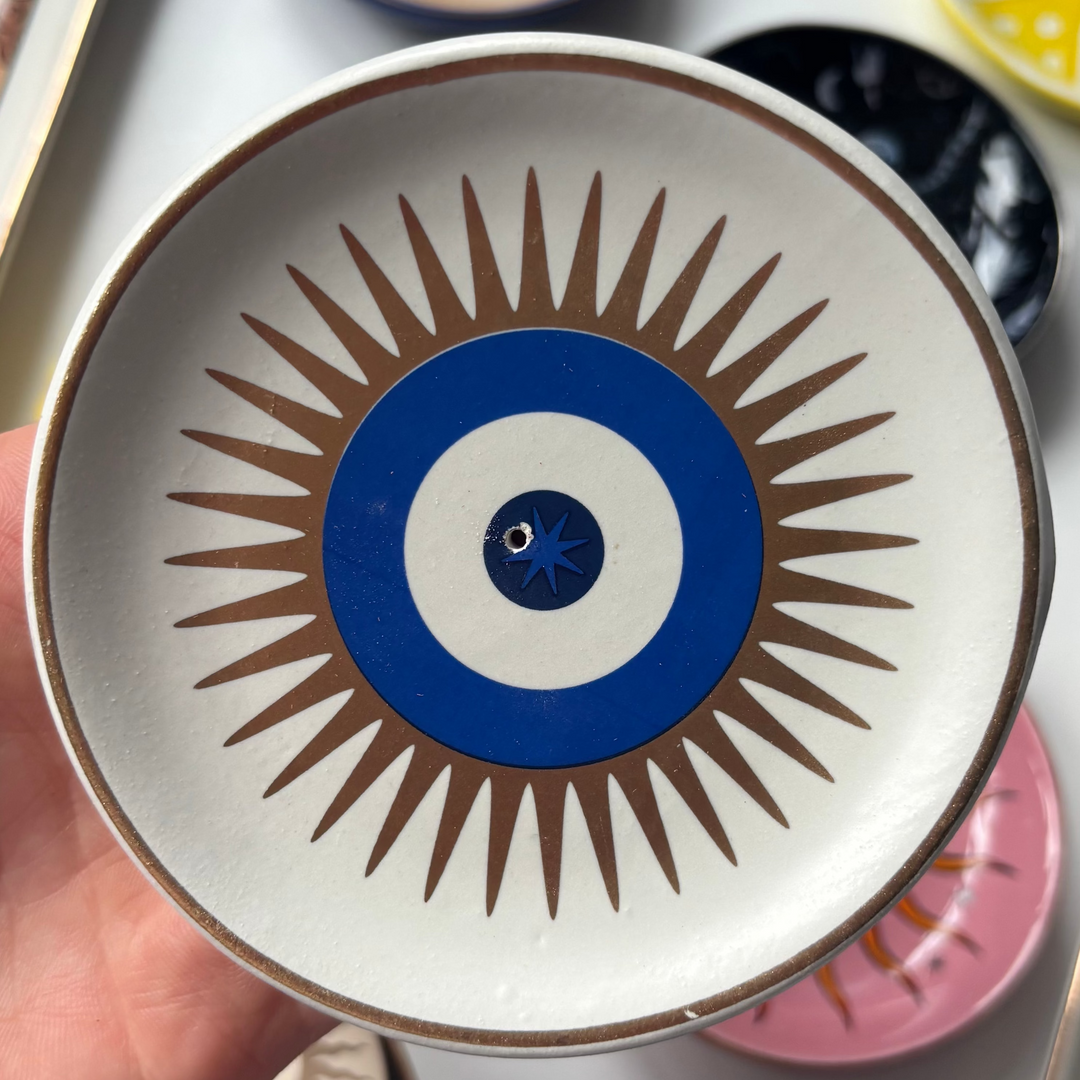 Decorative All Seeing Eye Incense Stick Holder held by a hand, surrounded by tarot cards and other decorative items.