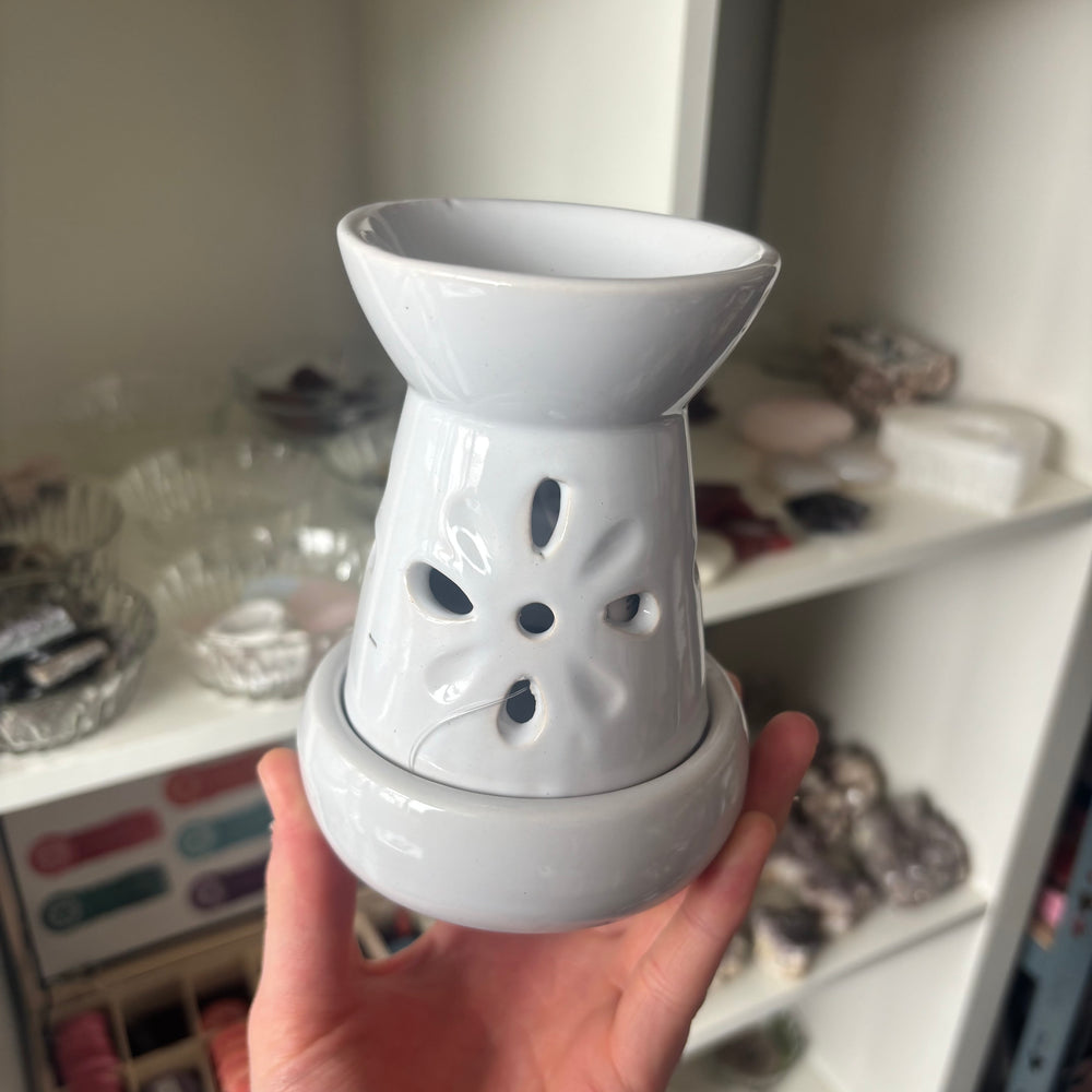 Floral Cut Out Oil and Wax Burner held in a hand in a brightly lit office