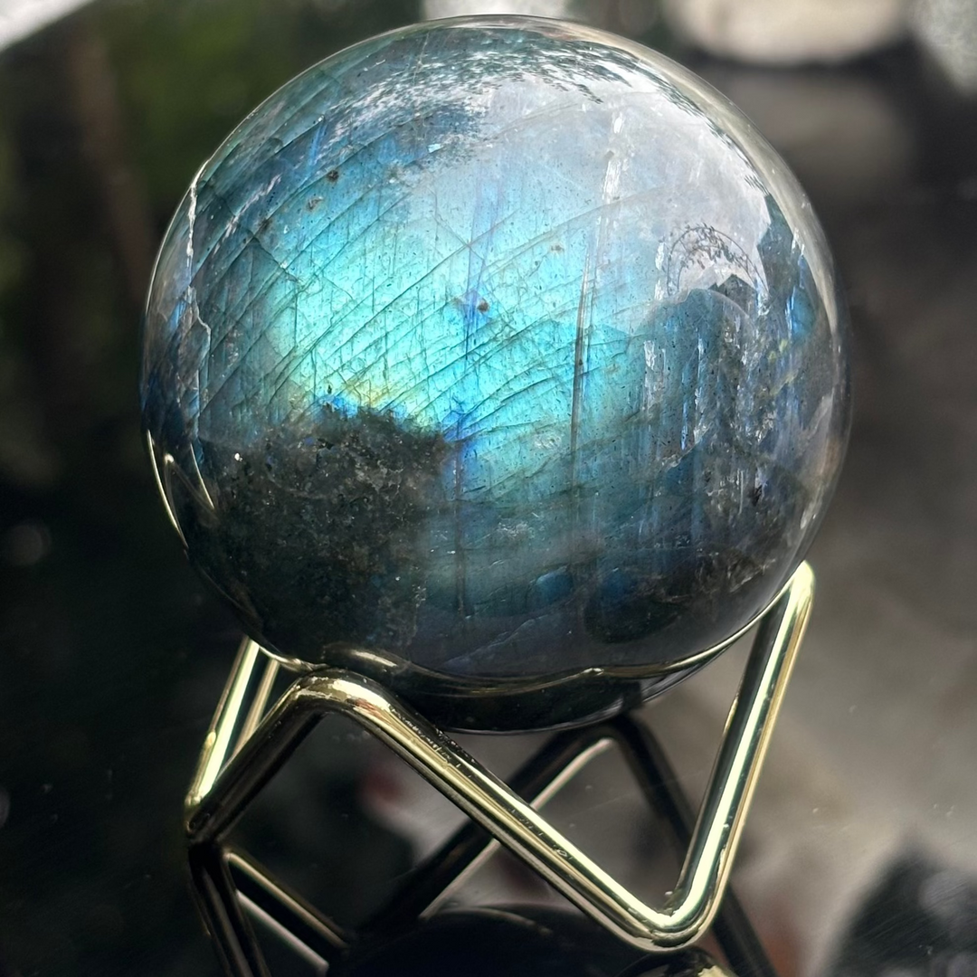A Labradorite Crystal Sphere on a glass reflective surface
