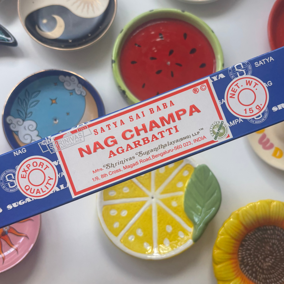 Box of Sai Baba Nag Champa incense with colorful ceramic plates in the background