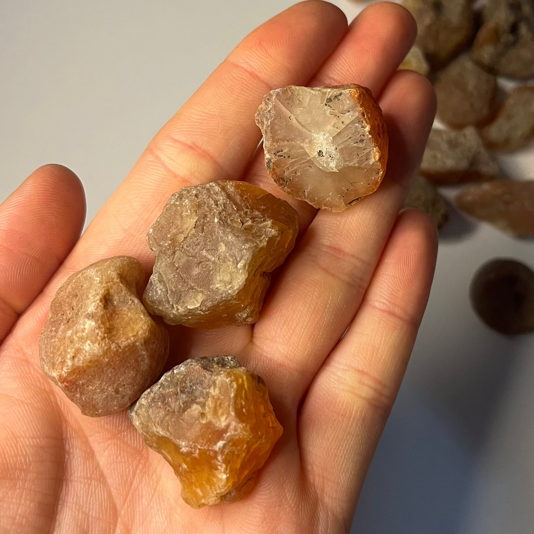 Some Raw Carnelian held in a hand in a bright sunny office