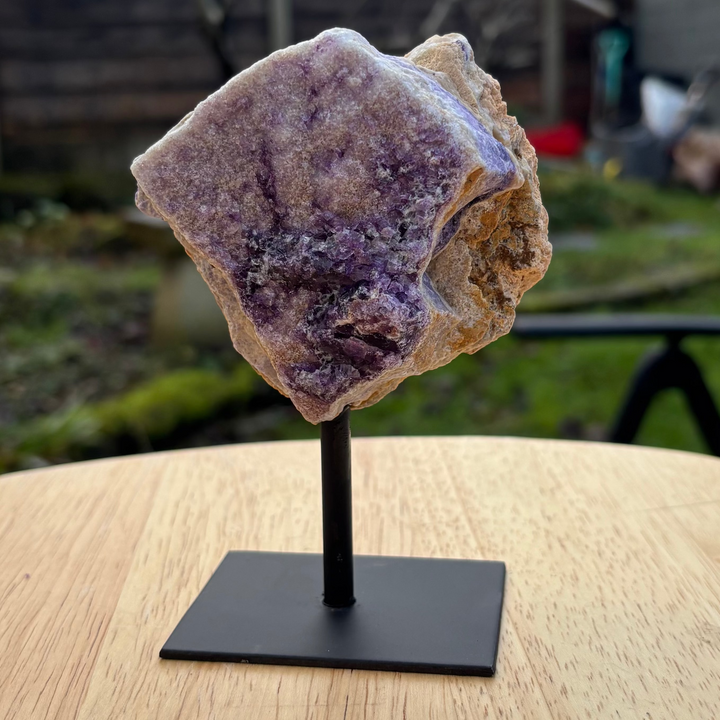 Fluorite crystal on a stand with a backyard setting in the background