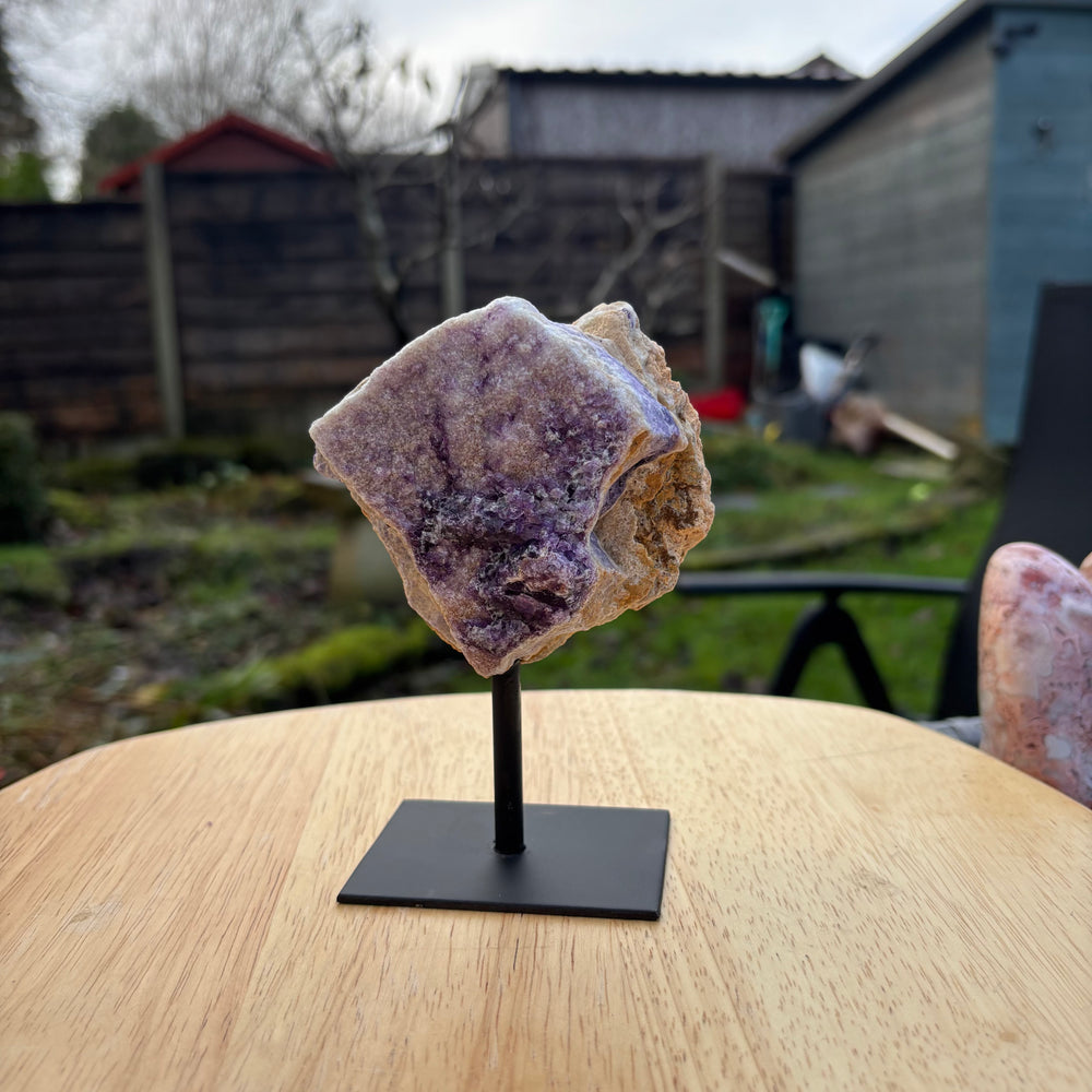 Fluorite crystal on a stand with a backyard setting in the background