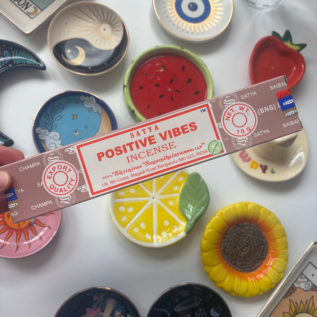 Satya Positive Vibes incense sticks box held over various small decorative plates.