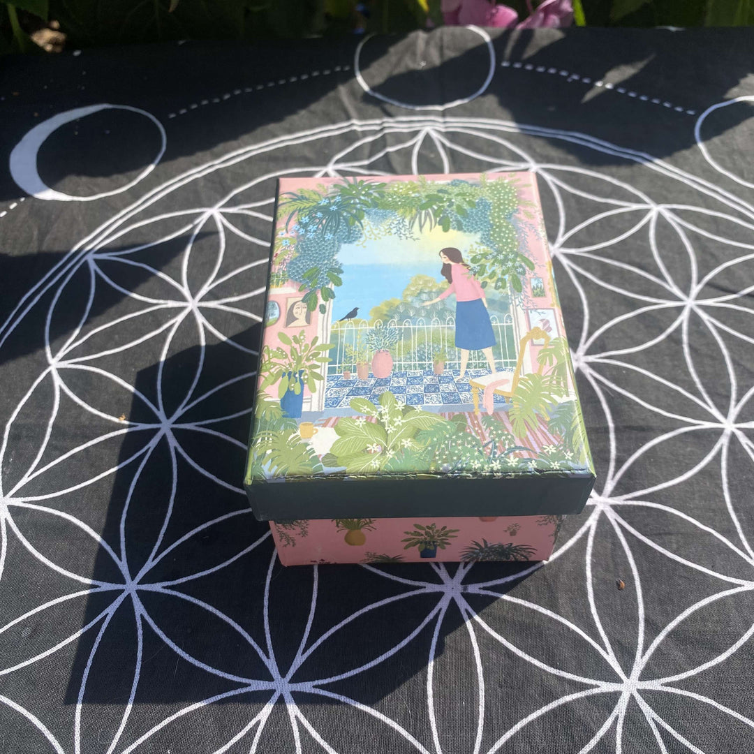 An alternative high-angle view looking down at the compact crystal starter kit gift box with its illustrated lid on. The layout highlights the charming size and vibrant packaging style, making it a perfect, ready-to-wrap gift for a loved one.