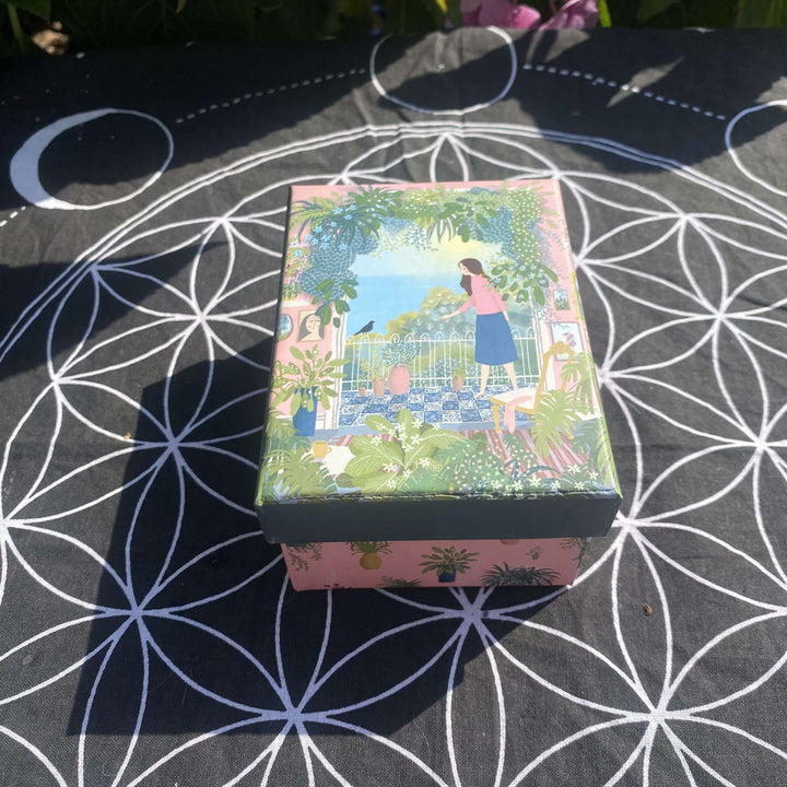 An alternative high-angle view looking down at the compact crystal starter kit gift box with its illustrated lid on. The layout highlights the charming size and vibrant packaging style, making it a perfect, ready-to-wrap gift for a loved one.