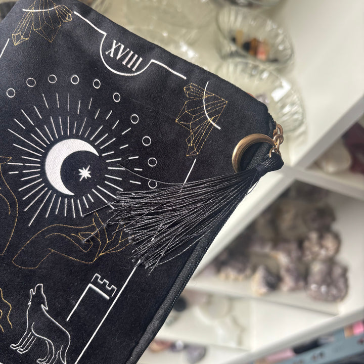 A close-up side angle of a black velvet ritual pouch showing the fine white line graphics and soft fabric texture
