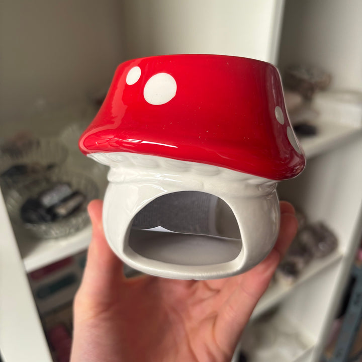 A close-up view of the back of the ceramic mushroom oil burner showing the large, rounded arched opening for a tea light candle. This functional space allows the warm flame to flicker safely while smoothly connecting with Root and Heart Chakra energies for grounded balance.