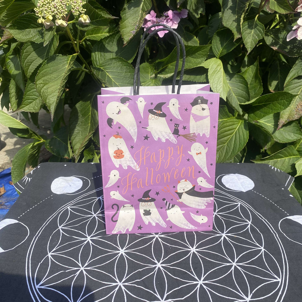 An outdoor flat lay on a black sacred geometry mat against garden leaves showcasing the bundle