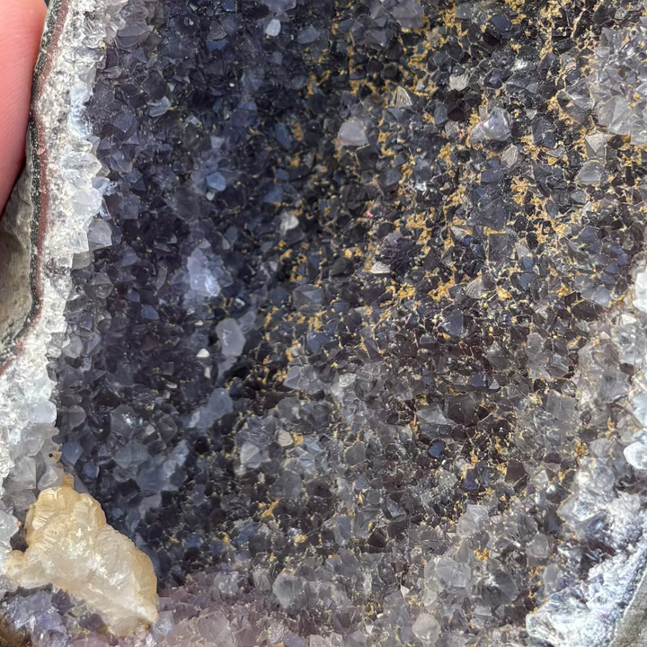 A detailed macro view focusing tightly on the deep purple crystalline structure and quartz border of the raw Amethyst piece. The texturised surface highlights the true, raw state of the crystal, ideal for creating a gentle sanctuary of stillness.