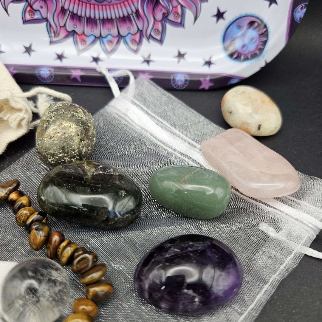 A detailed view of a shiny, metallic raw pyrite chunk clustered with a purple amethyst tumble and a pink rose quartz piece. This combination highlights a powerful shield to invite abundance, motivation, and total mental clarity into your home. 
