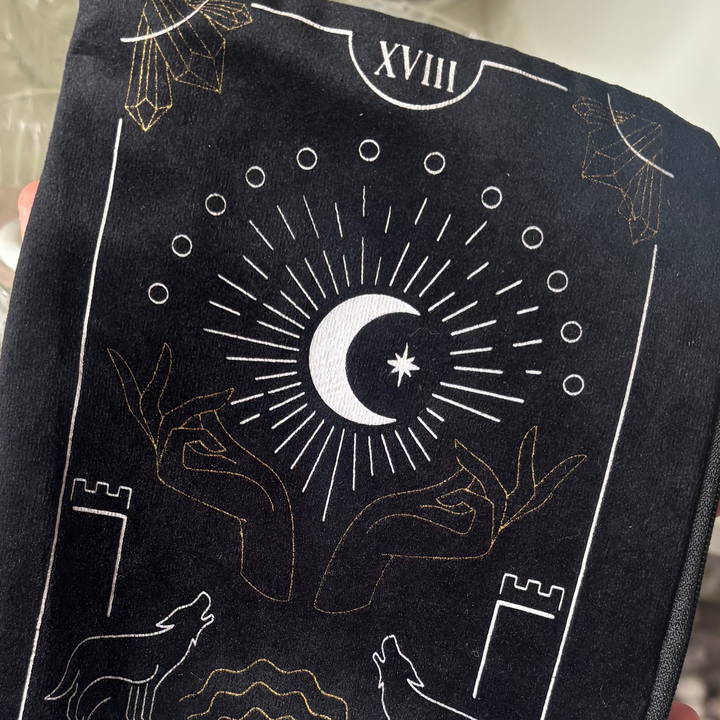 A detailed top-down view of a black velvet storage bag printed with the eighteen major arcana moon tarot card artwork