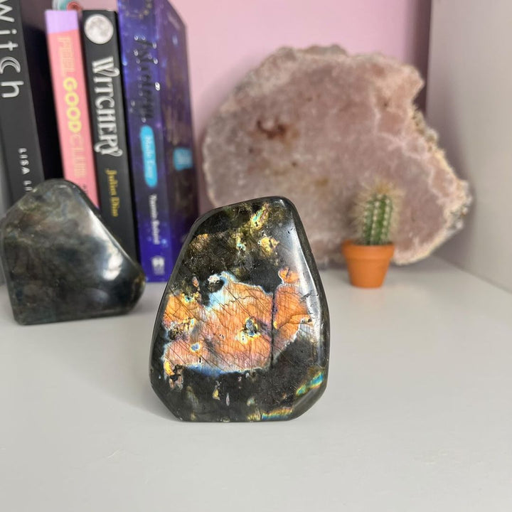 A Grade Labradorite Polished Freeform placed on a desk with books in the backround