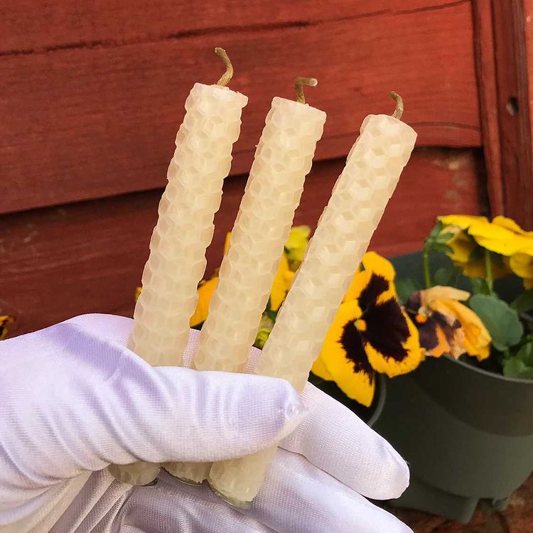 Three cream honeycomb beeswax spell candles for success rituals, rolled around linen wicks.