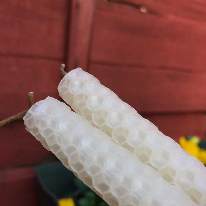 Detailed close-up of textured cream beeswax manifestation candles showing the honeycomb pattern.