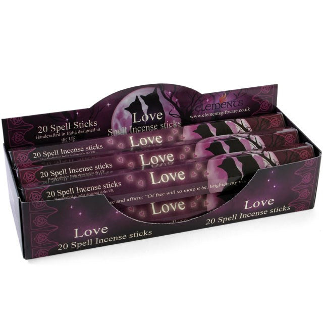 A cardboard counter display unit filled with Elements Love Spell incense stick boxes, featuring a dark pink and maroon mystical design.