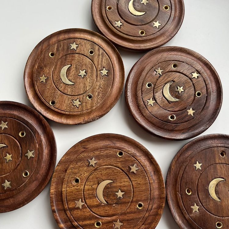 A collection of Sheesham wood incense stick holders with a moon and stars gold design.
