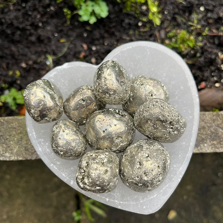 A heart shaped bowl containing shiny Pyrite crystals