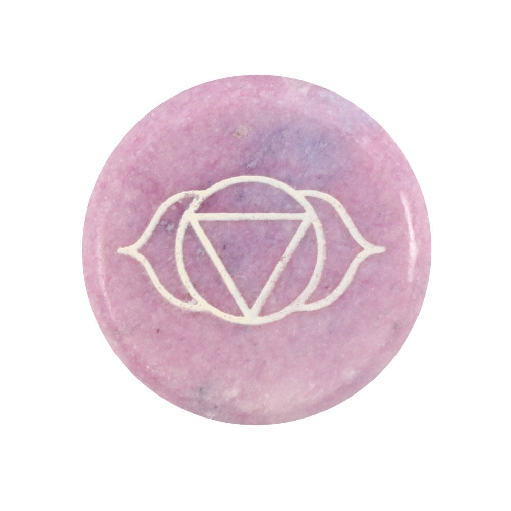 A flat, circular purple stone engraved with the geometric Third Eye chakra symbol (Ajna) highlighted in white detailing.