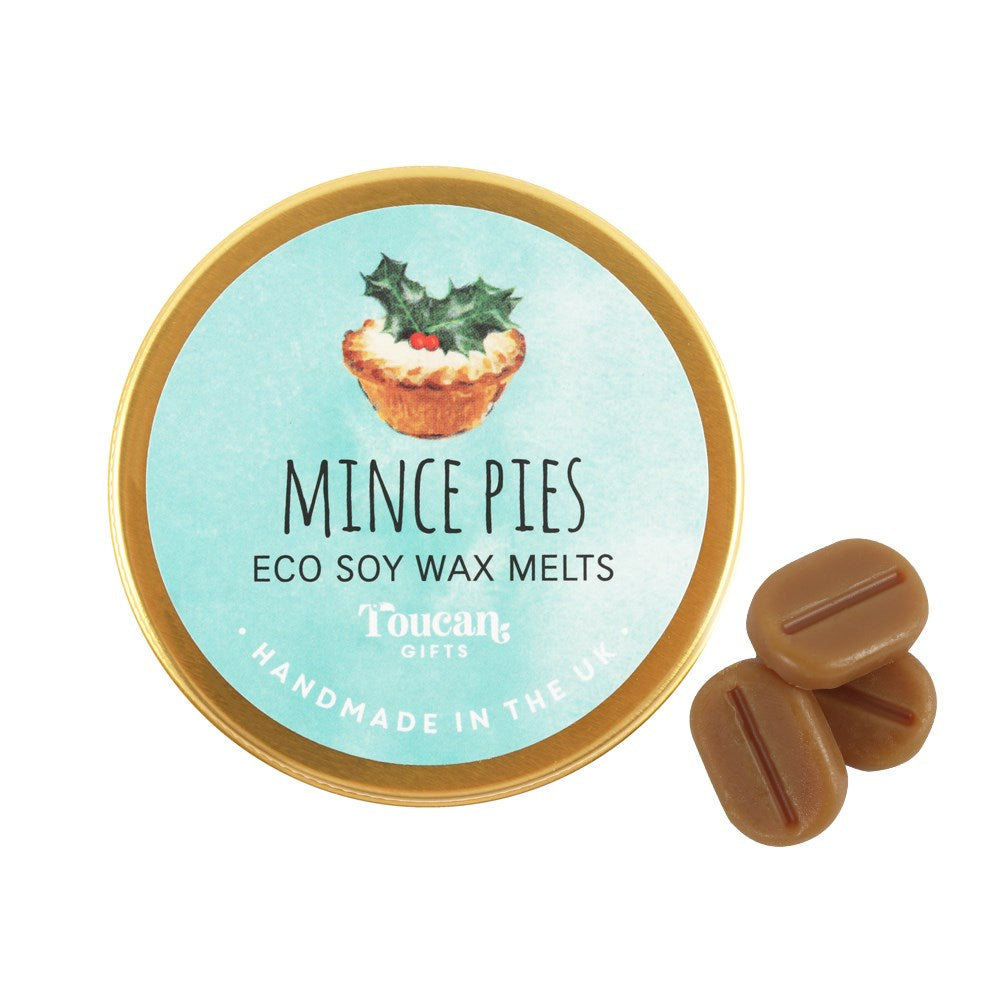 A top-down studio shot of the closed gold circular lid for the mince pies eco soy wax melts next to three loose mini melts, highlighting the handcrafted plastic-free design made for home fragrance rituals.