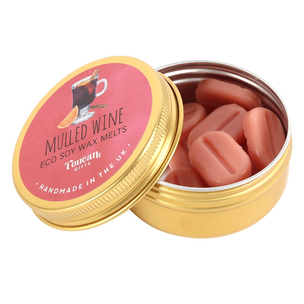 An open gold aluminium tin filled with small, pill-shaped reddish-pink soy wax melts, with its pink and gold circular product label leaning against the base on a clean white background.