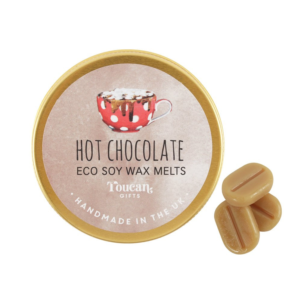 A top-down view of the closed golden circular lid for the hot chocolate eco soy wax melts next to three loose mini melts, highlighting the handcrafted plastic-free design made for home fragrance rituals.