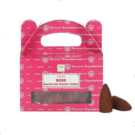 A wide shot of a pink patterned Satya Rose backflow dhoop cones retail box standing against a plain white background. Two loose, tapered brown incense cones sit beside the carry-handle package to highlight their traditional hand-rolled structure and comforting romantic intention.